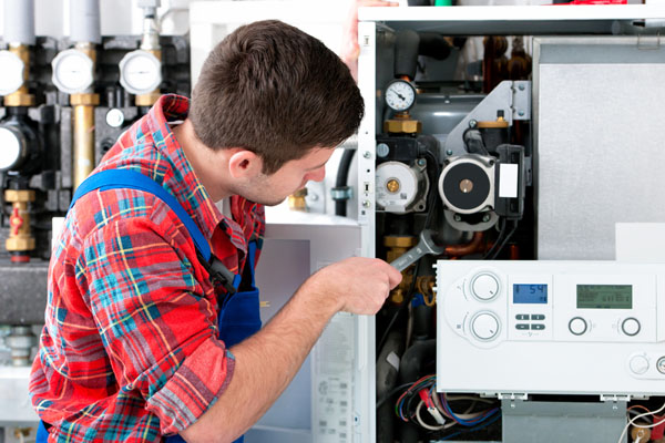 Heating technician repairing boiler controls in El Monte