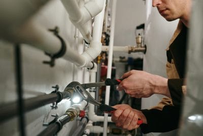 Technician inspecting commercial plumbing pipes in El Monte