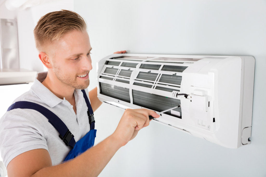 HVAC technician maintaining a ductless air conditioner in El Monte