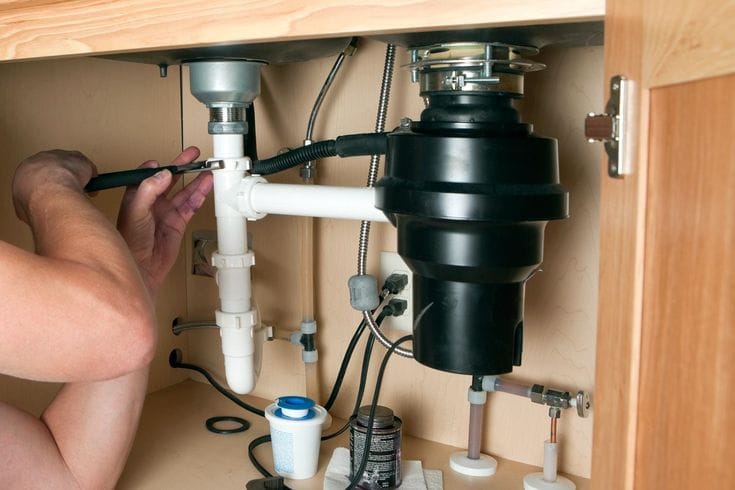 Plumber repairing a garbage disposal in El Monte